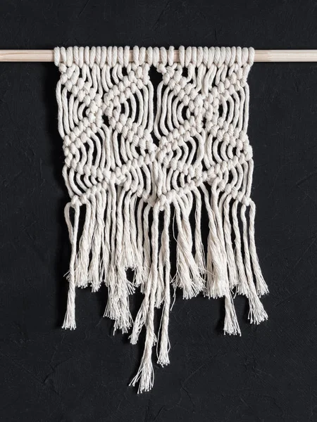 Macrame. Macrame weaving. White thread, black background, closeup