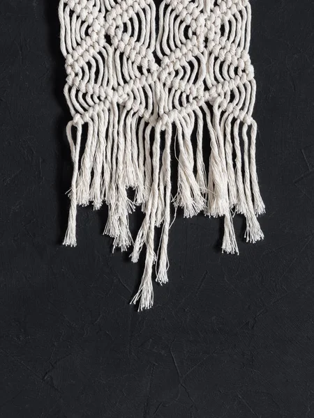 Macrame. Macrame weaving. White thread, black background, closeup