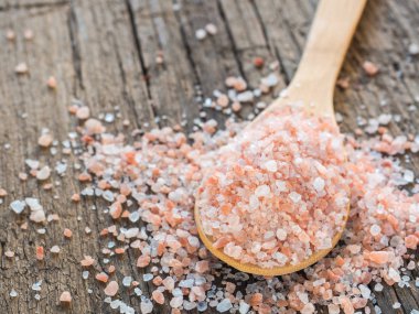 Himalaya tuz kaşık ahşap arka plan üzerinde pembe. Sağlıklı baharat tatlı