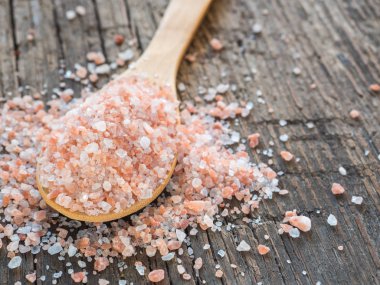 Himalaya tuz kaşık ahşap arka plan üzerinde pembe. Sağlıklı baharat tatlı