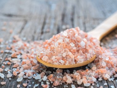Himalaya tuz kaşık ahşap arka plan üzerinde pembe. Sağlıklı baharat tatlı