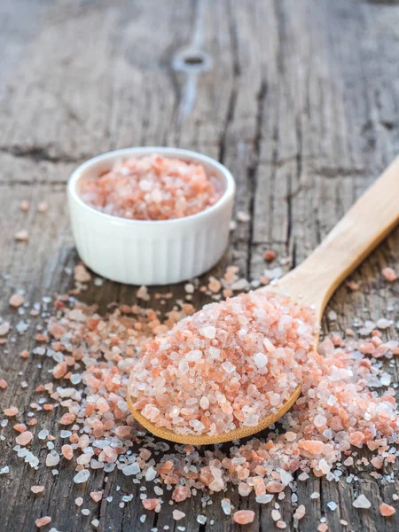 Himalaya tuz kaşık ahşap arka plan üzerinde pembe. Sağlıklı baharat tatlı