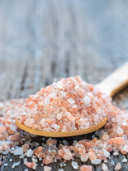 Himalaya tuz kaşık ahşap arka plan üzerinde pembe. Sağlıklı baharat tatlı