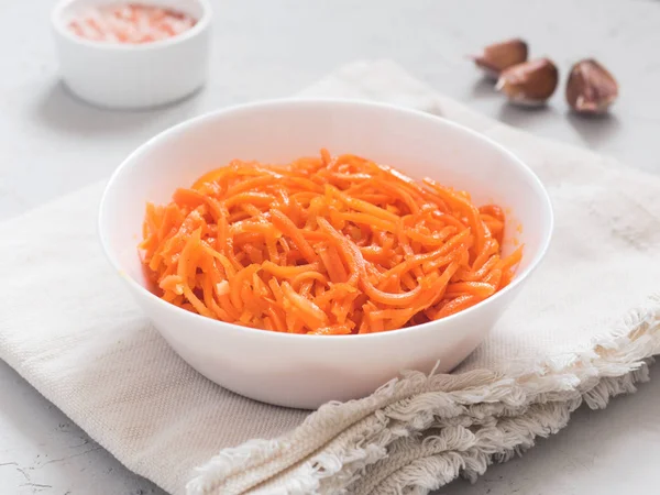 Fermente sebze, Kore havuç. Işık arka plan üzerinde beyaz tabak içinde Asya baharatlı salata