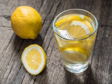 Taze temiz su bir bardak limon dilimleri ile. Ahşap masa limonata. Su yaşam, sağlıklı içecek