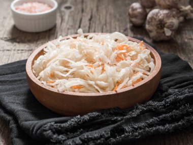 Lahana turşusu. Ahşap bir masa bir kahverengi kil tabağa fermente lahana. Sağlıklı vejetaryen yemek ve en iyi doğal probiyotik