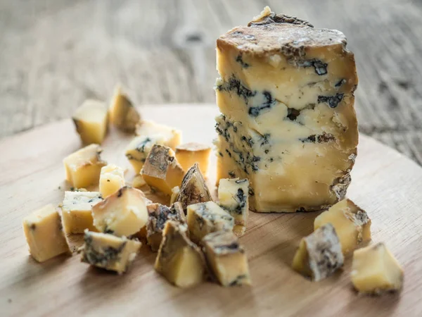 Skiva blå doftande engelsk ost Stilton med mögel på trä bakgrund. Närbild — Stockfoto