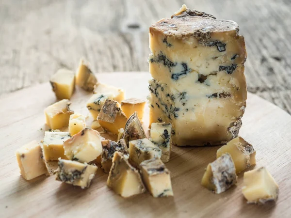 Rebanada de queso inglés fragante azul Stilton con molde sobre fondo de madera. Primer plano. — Foto de Stock