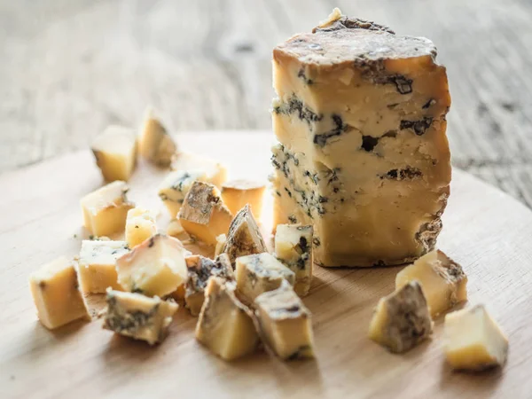 Rebanada de queso inglés fragante azul Stilton con molde sobre fondo de madera. Primer plano. — Foto de Stock