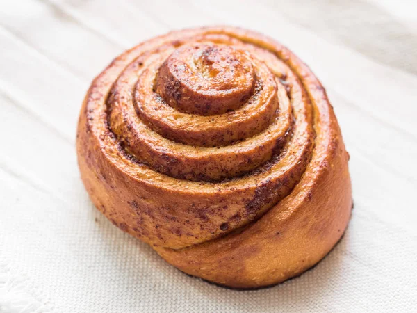 Pastelería horneada. Bollo suave dulce con canela sobre fondo blanco. Primer plano de Cinnabon —  Fotos de Stock