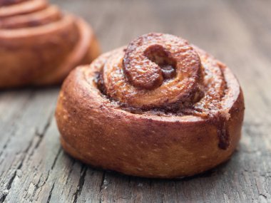 Şekerleme pişirme. Ahşap arka plan tarçın ile Tatlı taze yumuşak rulo topuz. Cinnabon yakın çekim