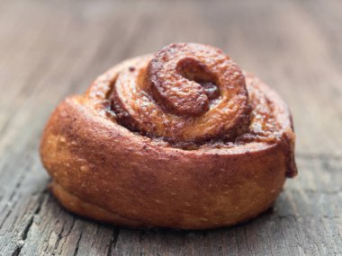 Şekerleme pişirme. Ahşap arka plan tarçın ile Tatlı taze yumuşak rulo topuz. Cinnabon yakın çekim