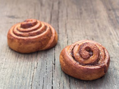 Şekerleme pişirme. Ahşap arka plan tarçın ile Tatlı taze yumuşak rulo topuz. Cinnabon yakın çekim