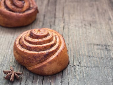 Şekerleme pişirme. Ahşap arka plan tarçın ile Tatlı taze yumuşak rulo topuz. Cinnabon yakın çekim