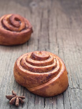 Şekerleme pişirme. Ahşap arka plan tarçın ile Tatlı taze yumuşak rulo topuz. Cinnabon yakın çekim