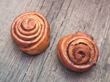 Şekerleme pişirme. Ahşap arka plan tarçın ile Tatlı taze yumuşak rulo topuz. Cinnabon yakın çekim