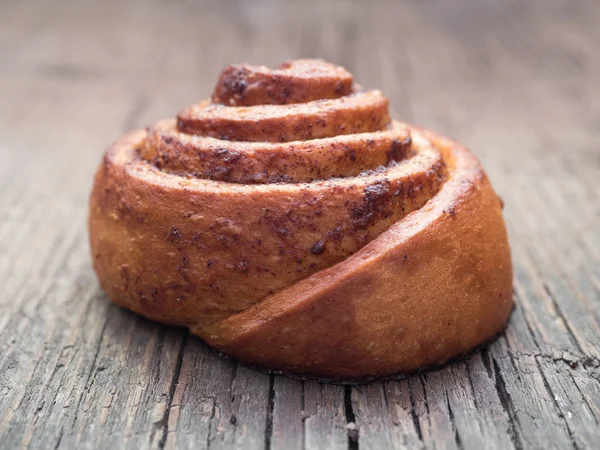 Cozimento de confeitaria. Pão de rolo macio fresco doce com canela no fundo de madeira. Cinnabon close-up — Fotografia de Stock