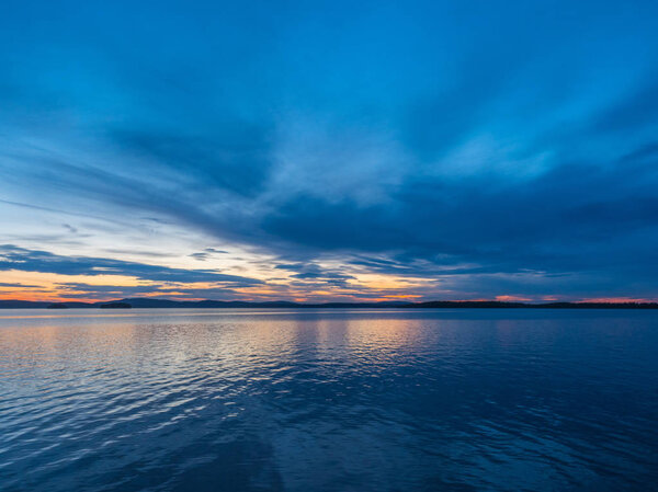 Calm, serenity, meditation concept. Sunset on the lake, quiet water, cloudless sky