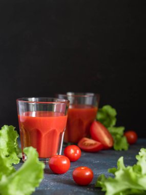 Sağlıklı yiyecekler. Olgun domates veya koyu bir arka plan üzerinde gözlük taze domates suyu ile Geleneksel İspanyol soğuk gazpacho çorbası