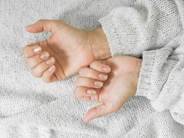 Manikür salon konsepti. Beyaz bir arka plan üzerinde altın tırnak manikür ile güzel kadın elleri. Altın oje. Closeup