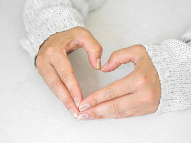 Manikür salon konsepti. Beyaz bir arka plan üzerinde altın tırnak manikür ile güzel kadın elleri. Altın oje. Closeup