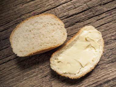 Tahtaya tereyağı sürülmüş beyaz ekmek dilimi. Üst Manzara. Yakın plan.