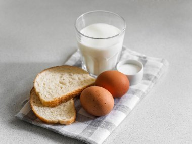 Kahvaltı malzemesi. Beyaz arka planda yumurta, süt ve ekmek dolu bir hayat. Yakın plan.
