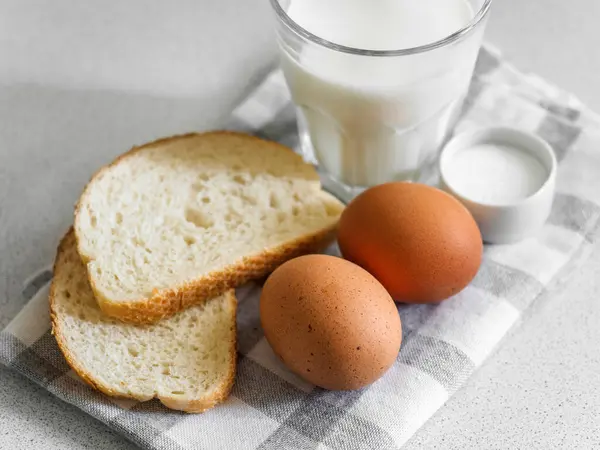 Kahvaltı malzemesi. Beyaz arka planda yumurta, süt ve ekmek dolu bir hayat. Yakın plan.