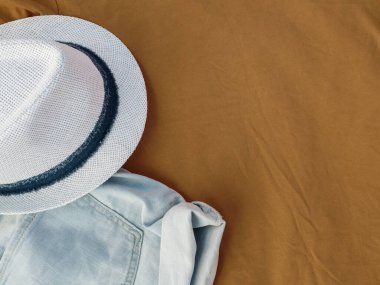 Plaj kıyafetleri: bej rengi seyahat arkaplanındaki şort ve şapka. Üst Manzara. Boşluğu kopyala