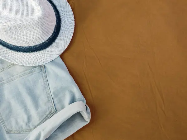 Flache Laien-Mode Frauen Sommer-Bademode-Accessoires: Shorts und Hut auf beigem Reisehintergrund. Ansicht von oben. Kopierraum — Stockfoto