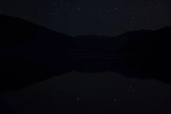 NIGHT SCENE FULL STAR SKY, MOUNTAIN AND REFLECTION ON ON THE LAKE — стоковое фото
