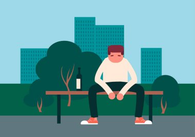 Üzgün bir genç adam bankta tek başına oturuyor..