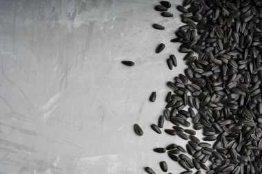 Kızarmış siyah ayçiçeği çekirdeği resmin sağ tarafında bir demet içinde duruyor. Kopyalama alanı ve yatay yönelimli resim