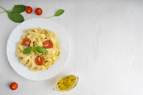 Bovenaanzicht Van Biologische Italiaanse Pasta Versierd Met Gesneden Tomaten Basilicum — Stockfoto