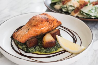 Somon bifteği fırında patates, ıspanak ve misket masasında limon.