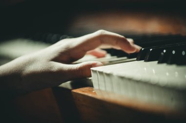 Eller piyano tuşlarında, yakın plan.