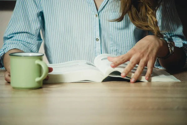 Masada kitap okuyan kız. Yakın plan.