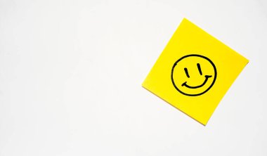 Beyaz arka planda gülen yüzlü sarı bir çıkartma var.