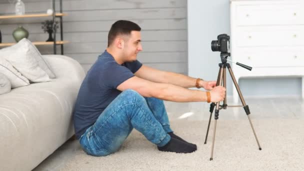 Νεαρός τραβούσε βίντεο με τη χρήση κάμερας σε τρίποδο. σύγχρονη τεχνολογία και blogging freelance έννοια εργασίας — Αρχείο Βίντεο