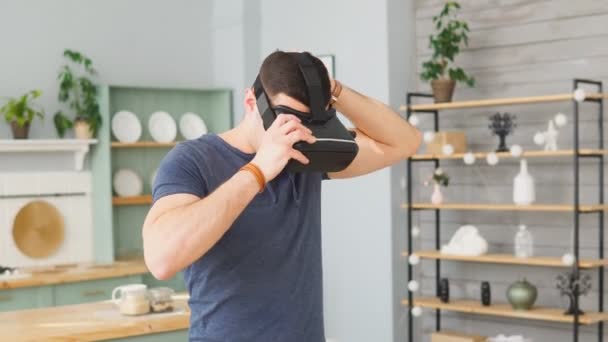 Az ember virtuális valóság szemüveget visel. Jóképű férfi VR headsetet használ otthon — Stock videók