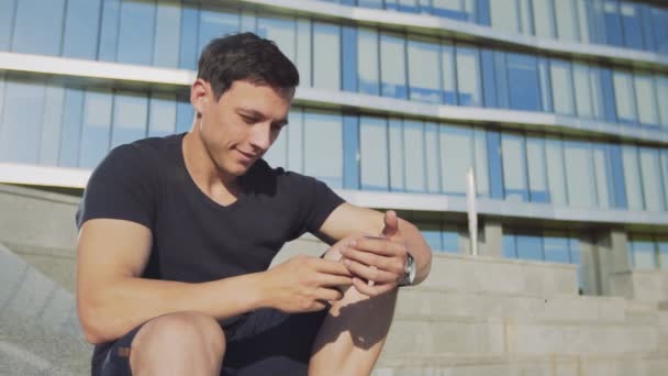 Молодий випадковий чоловік використовує смс-повідомлення смартфона на вулиці — стокове відео