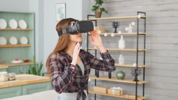Giovane ragazza che indossa occhiali di realtà virtuale. Bello donna utilizzando VR auricolare a casa — Video Stock