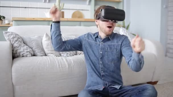 Возбужденный молодой человек с гарнитурой виртуальной реальности, играющий на воздушных барабанах VR 360 видеоигра дома — стоковое видео
