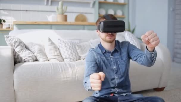 Young man is playing racing video game in 3D virtual reality simulator using headset. Driving car in VR glasses — 비디오