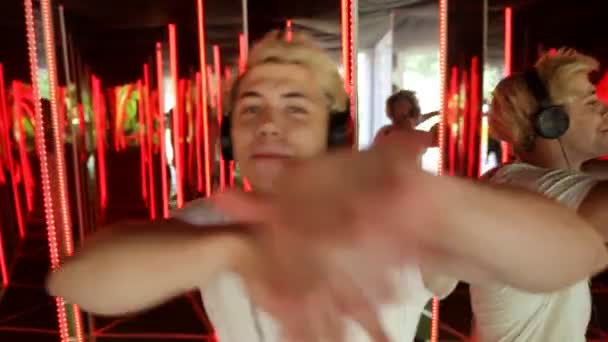 Mann mit Kopfhörer hört Musik und tanzt im Neonlicht-Hintergrund — Stockvideo