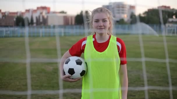 Πορτραίτο ενός γυναικείου ποδοσφαιρικού παίκτη του λυκείου με μια μπάλα ποδοσφαίρου — Αρχείο Βίντεο