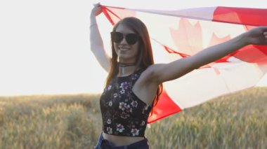 Gün batımında Kanada bayrağını ağır çekimde tutan vatansever genç kız..