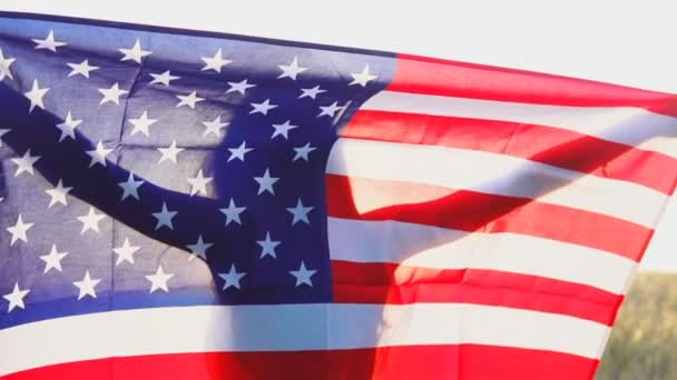 Jovencita patriótica con bandera de los Estados Unidos de América USA al atardecer. Movimiento lento — Vídeo de stock