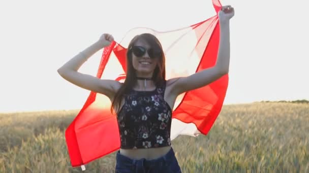 Retrato de una chica canadiense emocionada sosteniendo la bandera de Canadá al aire libre al atardecer. Movimiento lento — Vídeos de Stock