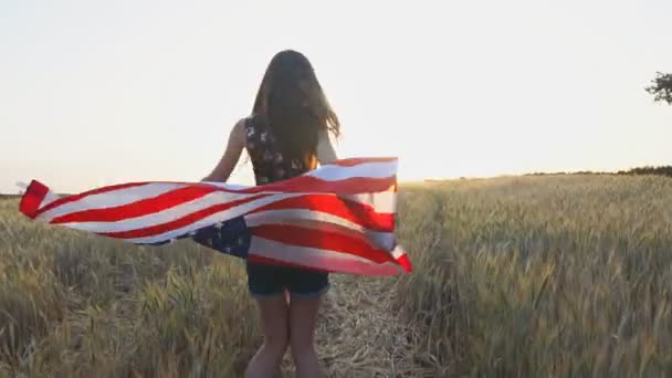 Молодая американка развлекается и позирует с флагом США — стоковое видео